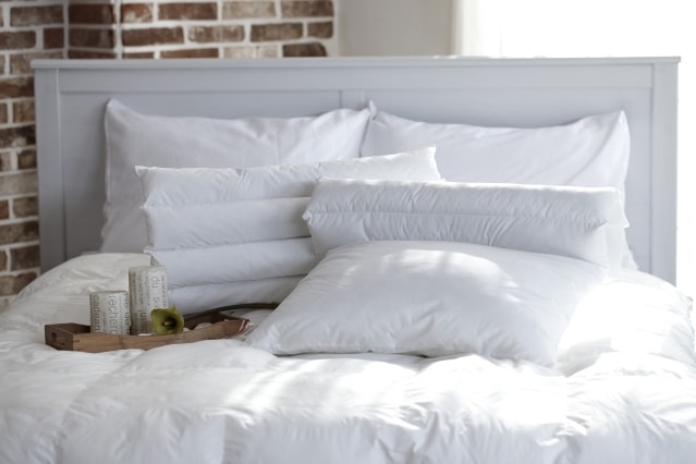 weißes Kopfkissen auf Bett