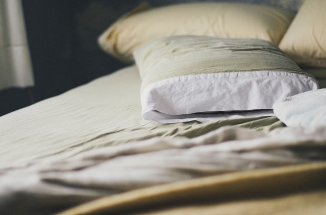 Kopfkissen und Bettwäsche auf Bett